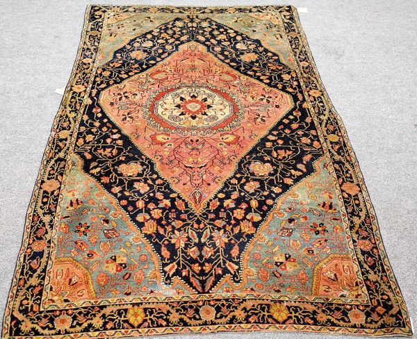 A Malayer rug, Persian, the black field with a large madder diamond, with central ivory roundel, pale indigo spandrels, all with delicate floral spray