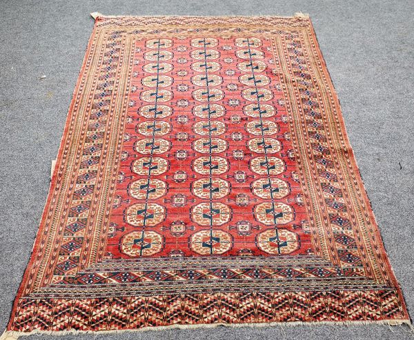 A Tekke Turkeman rug, the madder field with three columns of twelve guls, styled crosses; a cross border, skirt ends, 210cm x 133cm.