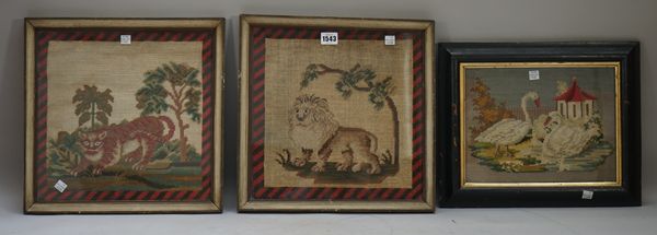 A pair of Victorian woolwork pictures depicting a lion and a tiger against landscapes, each within a striped black and red border, framed and glazed,