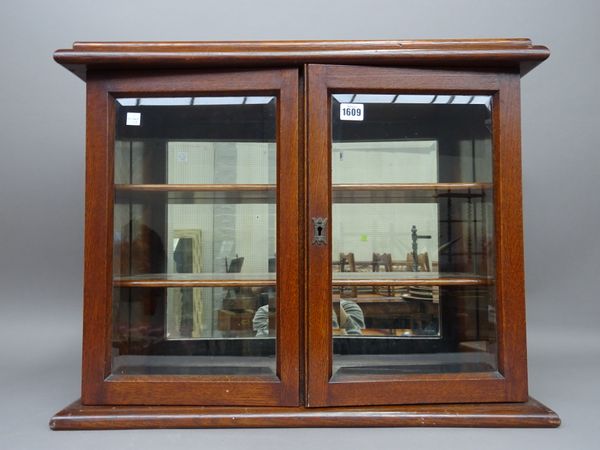 An early 20th century oak glazed hanging two door cupboard, 66cm wide x 52cm high.