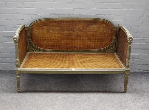 A 19th century and later green painted French small sofa, with cane back and sides on fluted supports, 128cm wide x 71cm high.