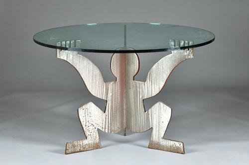 After Keith Haring 1958-1990; a circular glass top kitchen table on polished steel figural trefoil support, 120cm diameter x 75cm high.