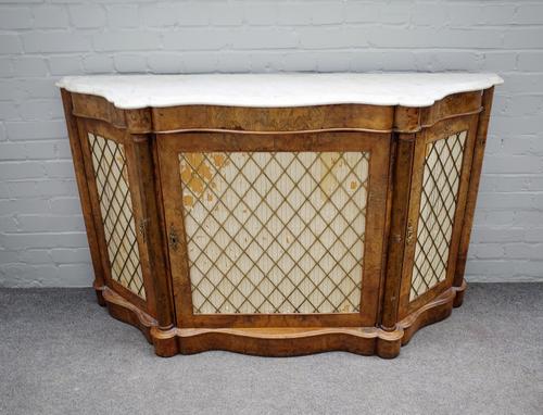 A Victorian credenza, the serpentine marble top over three grill doors divided by columns, 153cm wide x 90cm high.