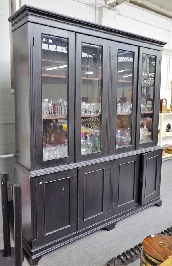 A 19th century French ebonised side cabinet, with four glazed doors over four panel cupboards on bracket feet, 208cm wide x 243cm high.