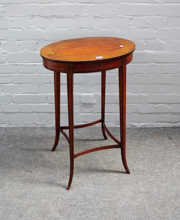 A George III mahogany, harewood and satinwood oval work table, with hinged banded top on square splayed satinwood legs (lacks basket drawer), 75cms hi