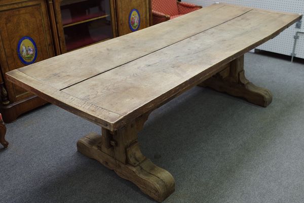 A 17th century style oak refectory table, the cleated plank top on a pair of trestle supports, 90cm wide x 233cm long.