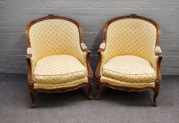 A pair of Louis XV style beech framed tub back armchairs, on scroll feet, 70cm wide x 85cm high. (2)