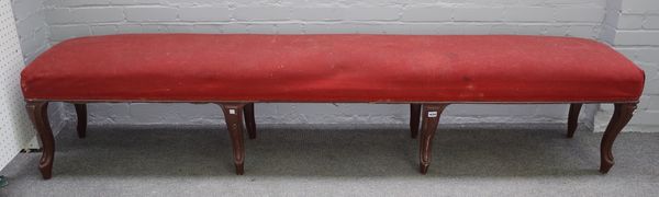 A large 19th century French rectangular stool on eight brown painted cabriole supports, 232cm wide x 50cm high.