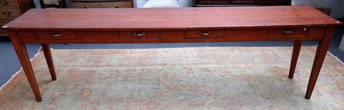 An early 19th century French fruitwood and pine serving table, with four frieze drawers, on tapering square supports, 281cm wide x 76cm high.