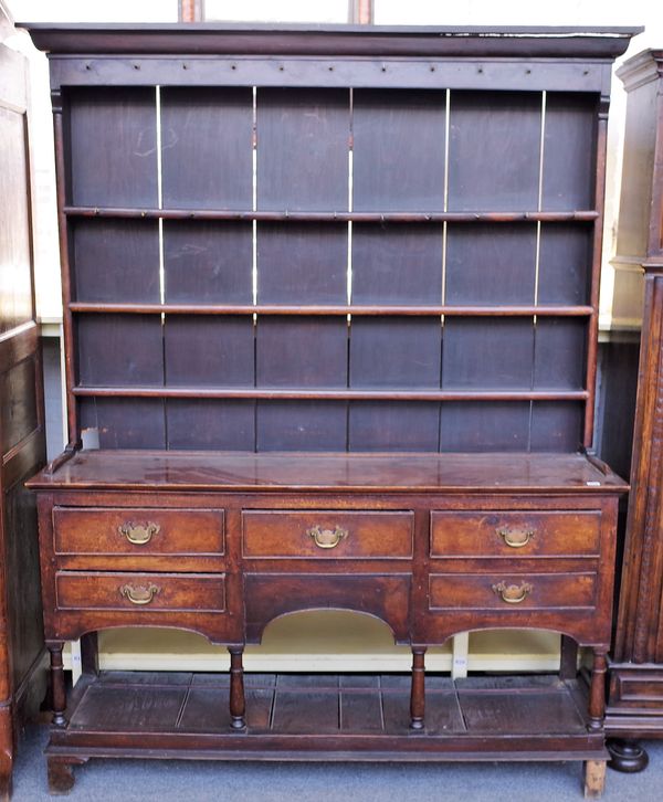 A mid-18th century oak dresser, the enclosed three tier plate rack over five frieze drawers, on turned supports, united by potboard undertier, 166cm w