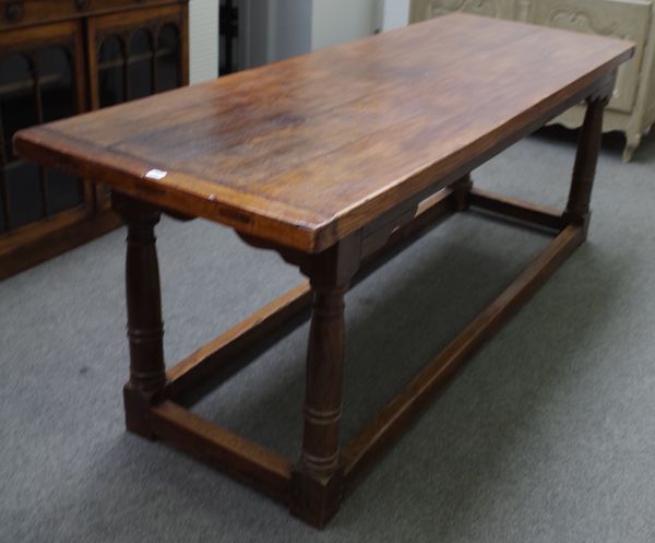 A 17th century style oak refectory table, the cleated plank top on turned supports, united by perimeter stretcher, 77cm wide x 216cm long.    51