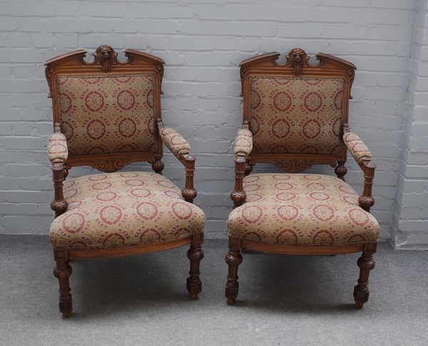 A pair of late French walnut framed open armchairs, each with cartouche crest and fluted supports 65cm wide x 110cm high. (2) 1893