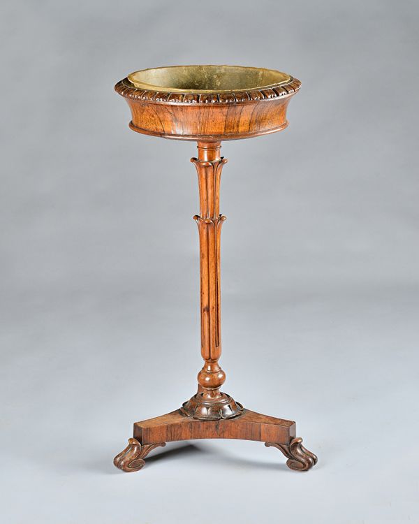 A William IV rosewood jardinière, the flared circular top on carved "palm tree" style column and three scroll feet, 44cm diameter x 90cm high.  Illust