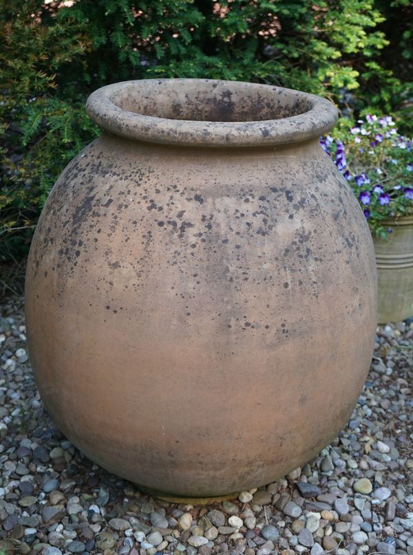 A large terracotta oil jar, of bulbous tapering form, with banded body, 110cm high.