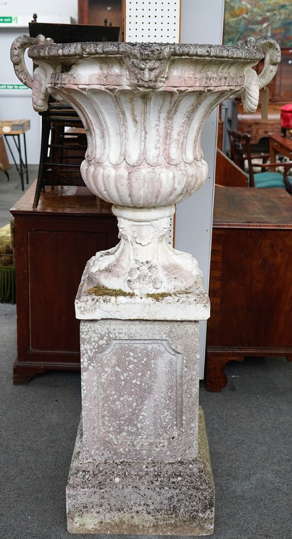 A large reconstituted stone jardinière with twin scroll handles on stepped square pedestals, 95cm diameter x 169cm high.