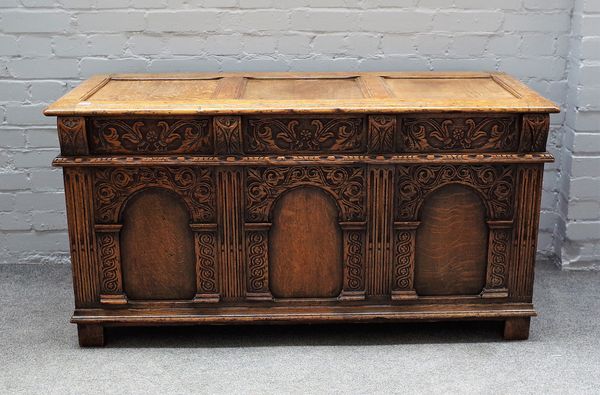 A 17th century style oak coffer, with triple panel lid and front, on stile feet, 137cm wide x 71cm high.  56