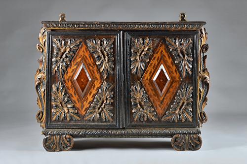 A 17th century Italian or South German parquetry table top cabinet, with pair of parcel gilt ebonised doors inset with walnut and birch diamond panels