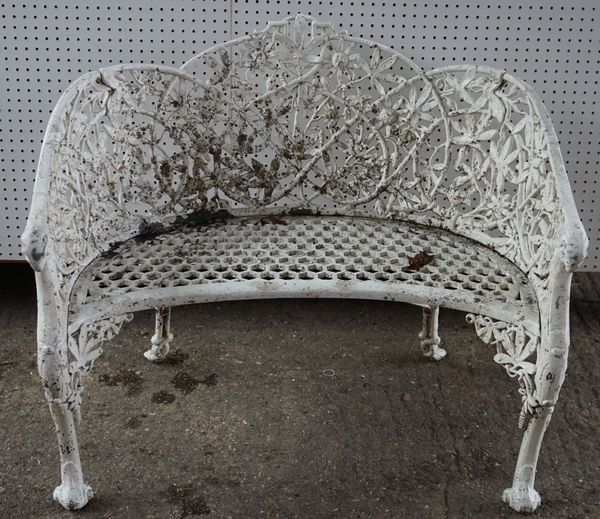 A pair of white painted Coalbrookdale style cast aluminum shaped benches, each with design of interlaced flowers on shaped legs, 104cm wide. (2)