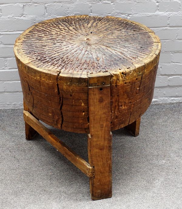 A 19th century oak tree trunk chopping block, with metal inset top on three block supports, 60cm diameter x 64cm high.