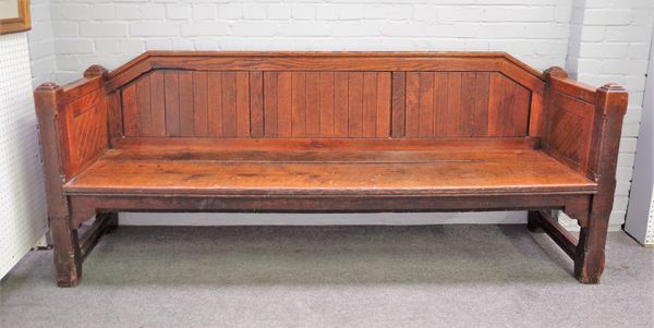 A Victorian Gothic Revival oak pew with tongue and groove back and panel sides on canted block supports, 230cm wide x 92cm high.