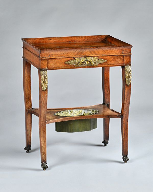 An early 19th century French Empire mahogany and gilt metal mounted rectangular side table, tray top and a frieze drawer on sabre legs united by under