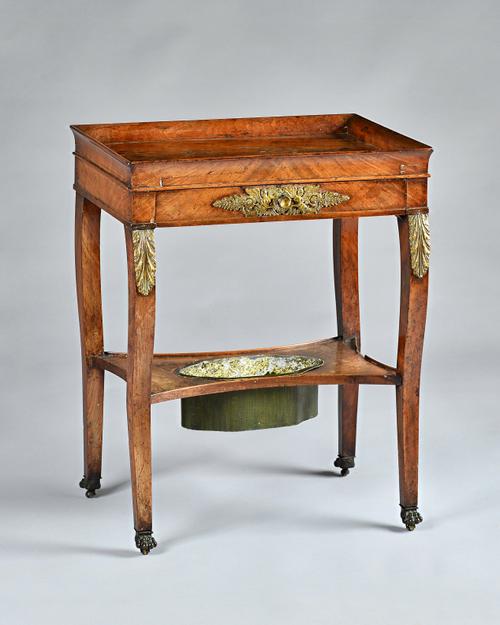 An early 19th century French Empire mahogany and gilt metal mounted rectangular side table, tray top and a frieze drawer on sabre legs united by under
