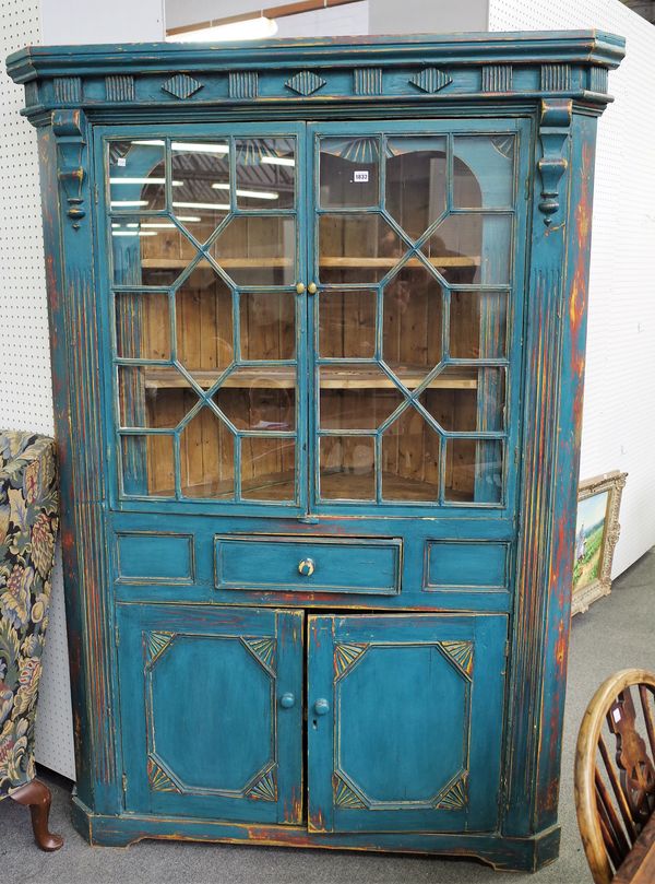 A 19th century Irish blue painted pine corner cupboard with pair of astragal glazed doors over single drawer and pair of cupboards, 140cm wide x 204cm