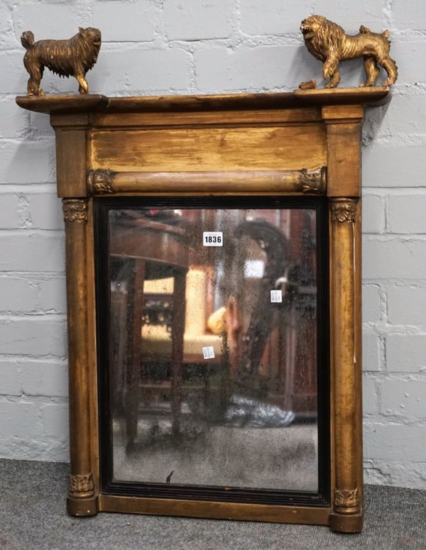 A small Regency gilt mirror with opposing lion and dog finials, over rectangular mirror plate and split turned moulding, 57cm wide x 80cm high.