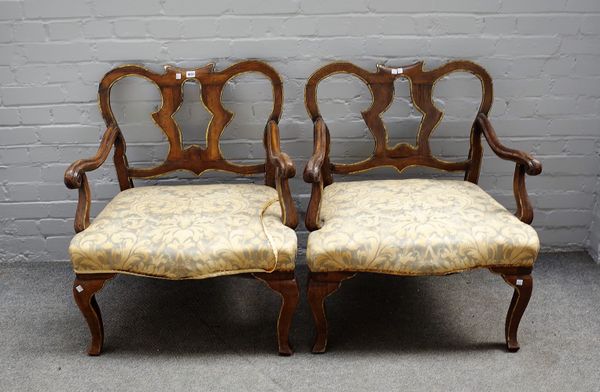 A pair of mid-18th century Italian walnut and parcel- gilt open armchairs, probably Tuscany, backs reduced in height, 81cms high (2).