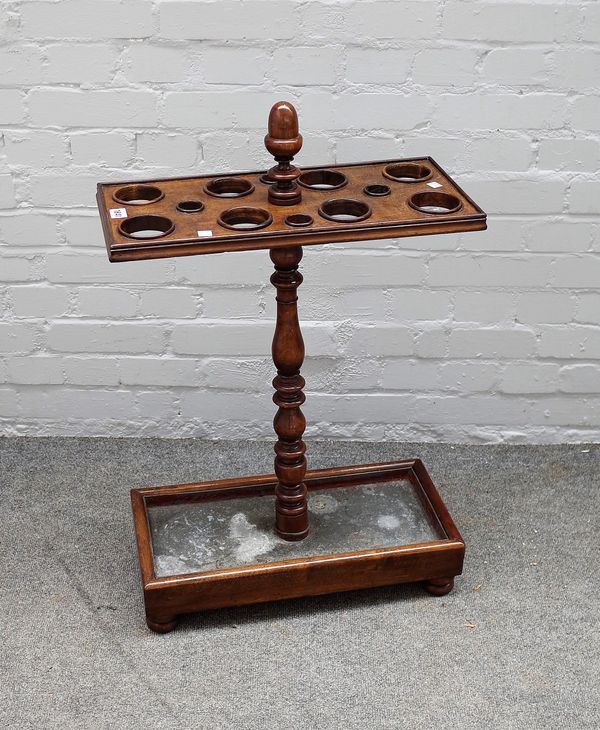 A Victorian stained beech umbrella stand, on ring turned baluster support and rectangular base, zinc liner and bun feet 52.5cms wide, 80cms high.