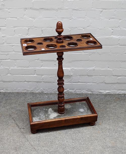 A Victorian stained beech umbrella stand, on ring turned baluster support and rectangular base, zinc liner and bun feet 52.5cms wide, 80cms high.