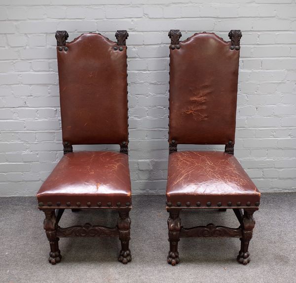 A pair of 19th century Continental oak leather upholstered side chairs on caryatid supports and lion paw feet, 47cm wide x 116cm high (2).