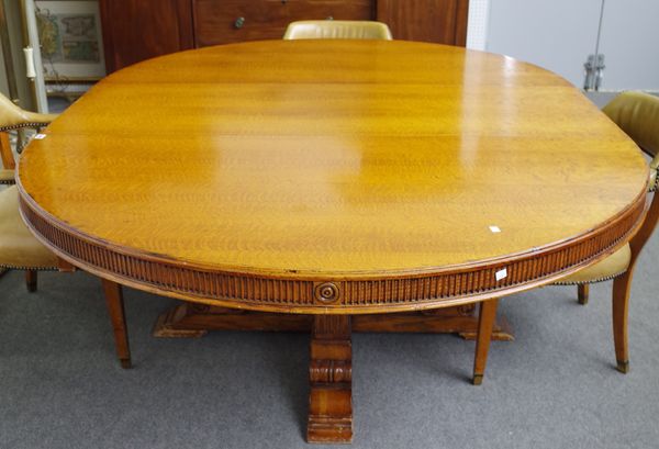 Ralph Lauren; a 20th century oak circular extending dining table on four fluted square columns, one extra leaf, 162cm diameter x 218cm long extended.