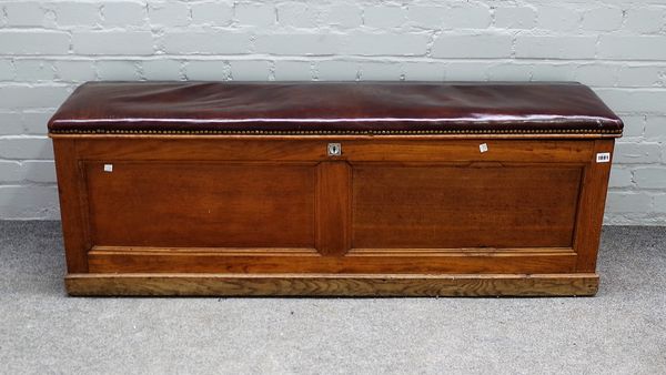 A late 19th Century oak porch coffer, with lifting leather padded seat, with carrying handles to either side, 137cms wide, 47cms high.