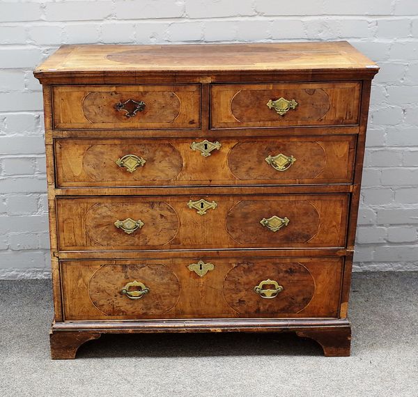 A George I figured walnut and burr yew chest, with two short and three long graduated drawers, on bracket feet, 94cm wide x 92cm high.