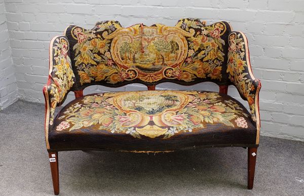 A late Victorian stained beech framed settee, with shaped back upholstered with polychrome floral needlework with lake landscapes 113cms wide, 90cms h