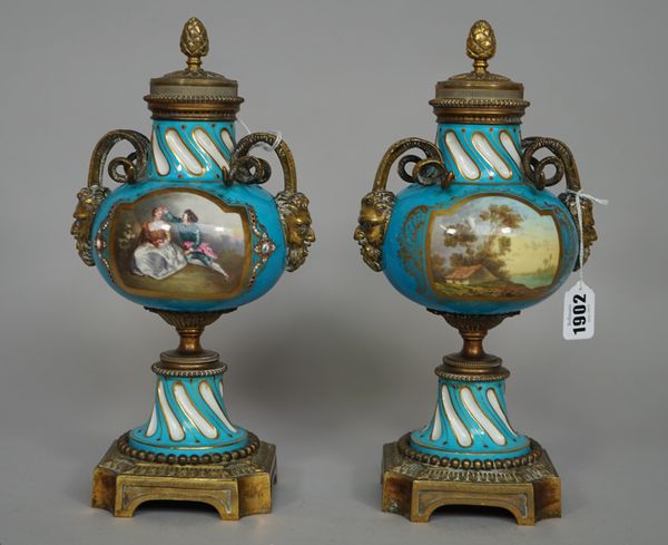 A pair of Paris porcelain and gilt metal cassolette vases, late 19th century, each decorated with panels of figures and landscapes against a turquoise