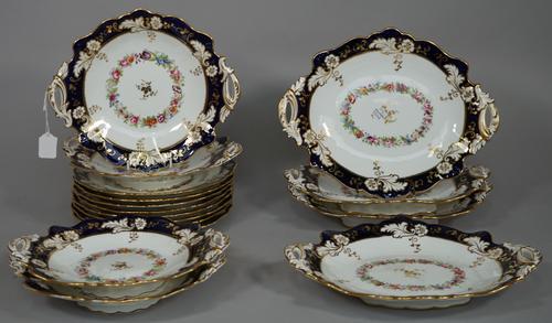 A Ridgway porcelain part dessert service, circa 1850, each piece decorated with a floral garland inside a deep blue and gilt foliate border, comprisin