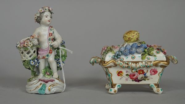 A Derby figure of a putto, circa 1765-70, modelled standing against a flowering tree carrying a basket of flowers under his right arm, 13cm. high; als