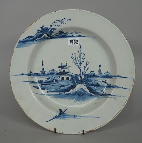 A large English delftware blue and white deep plate, probably London, circa 1770, painted with a rim-to-rim Chinese landscape with a two-storey pagoda