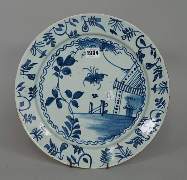 An English delftware blue and white plate, mid-18th century, painted with an insect, flowers and a tent, 33cm. diamter.