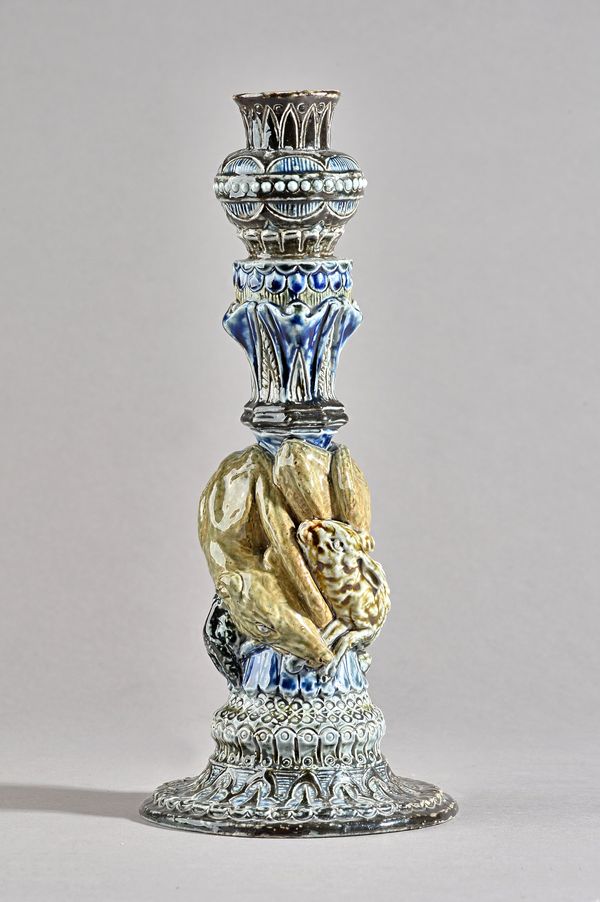 A Martin Brothers stoneware candlestick, the column moulded in relief with a dog attacking two hares, incised mark to base, `R.W. Martin, London', (a.