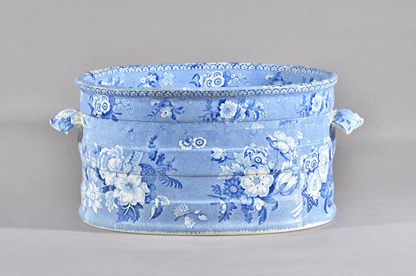 A Staffordshire blue and white printed two-handled oval footbath, 19th century, of small proportions, printed to the interior with a large vase of flo