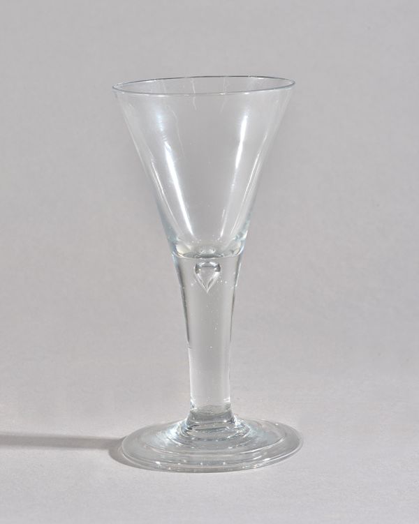 A tall plain-stemmed wine glass, mid-18th century, the drawn trumpet bowl raised on a teared stem and folded foot, 20.5cm. high. Illustrated