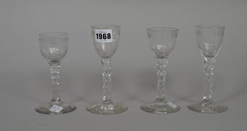 Four engraved facet-stemmed wine glasses, late 18th, including a pair and one engraved with a floral border, (a.f), 13.5cm. to 15cm. high, (4).