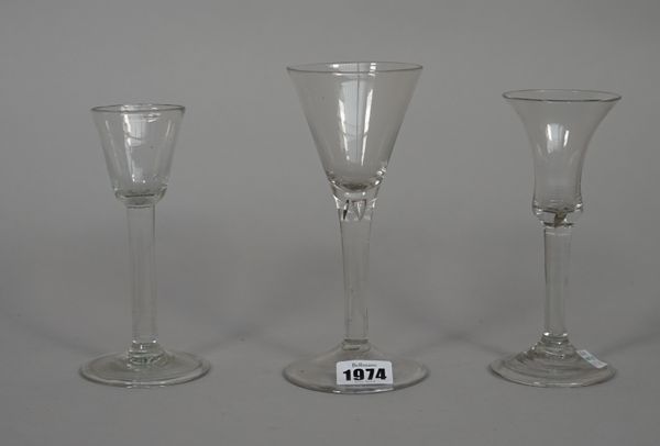 Three plain-stemmed wine glasses, mid 18th century, the first with waisted bell bowl and folded foot; the second with rounded funnel bowl and folded f