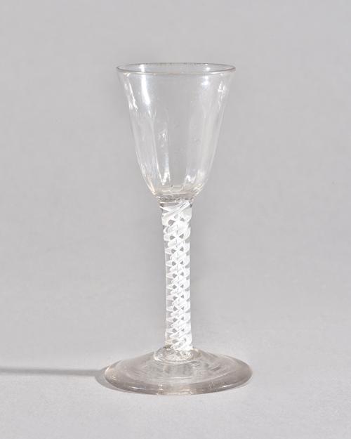 An opaque twist wine glass, circa 1765, the moulded rounded funnel bowl raised on a double series opaque twist stem and plain foot, 14.75cm. high. Ill