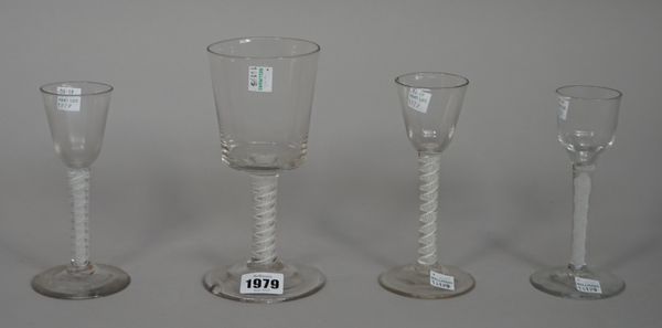 Four opaque twist wine glasses, circa 1765, comprising; a large glass with bucket bowl raised on a double series opaque twist stem, 17.5cm. high; two