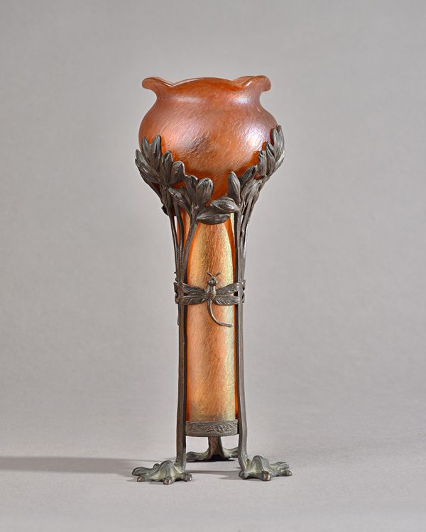 A Loetz Art Nouveau orange iridescent glass vase, c.1906, mounted in a metal frame cast with dragonfly and flwers, 26.5cm high. Illustrated