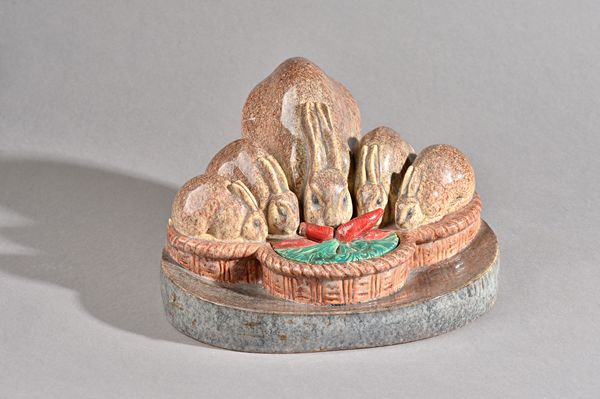 An Art Deco pottery inkwell, stamped Etling Paris and incised 'Sevin Marcel Guillard', moulded with a rabbit family group munching carrots on a shaped